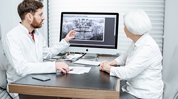 implant dentist in Longmont showing a patient their X-rays 