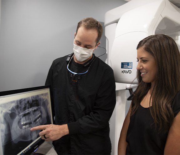 Dentist and dental patient reviewing dental x-rays