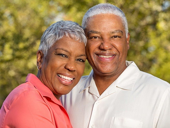 Man and woman smiling after dental bonding treatment