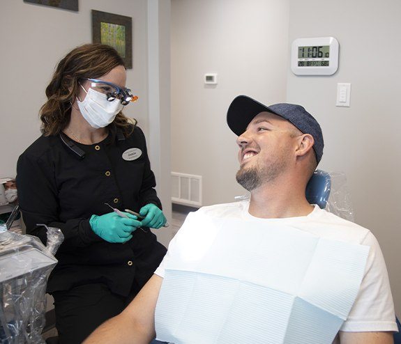 Man smiling at dental team member during dental bonding treatment