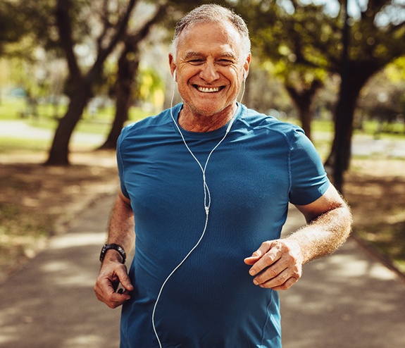 An older man with dental implants in Longmont jogging