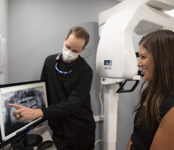 Dentist and patient looking at x-rays of teeth in need of root canal treatment